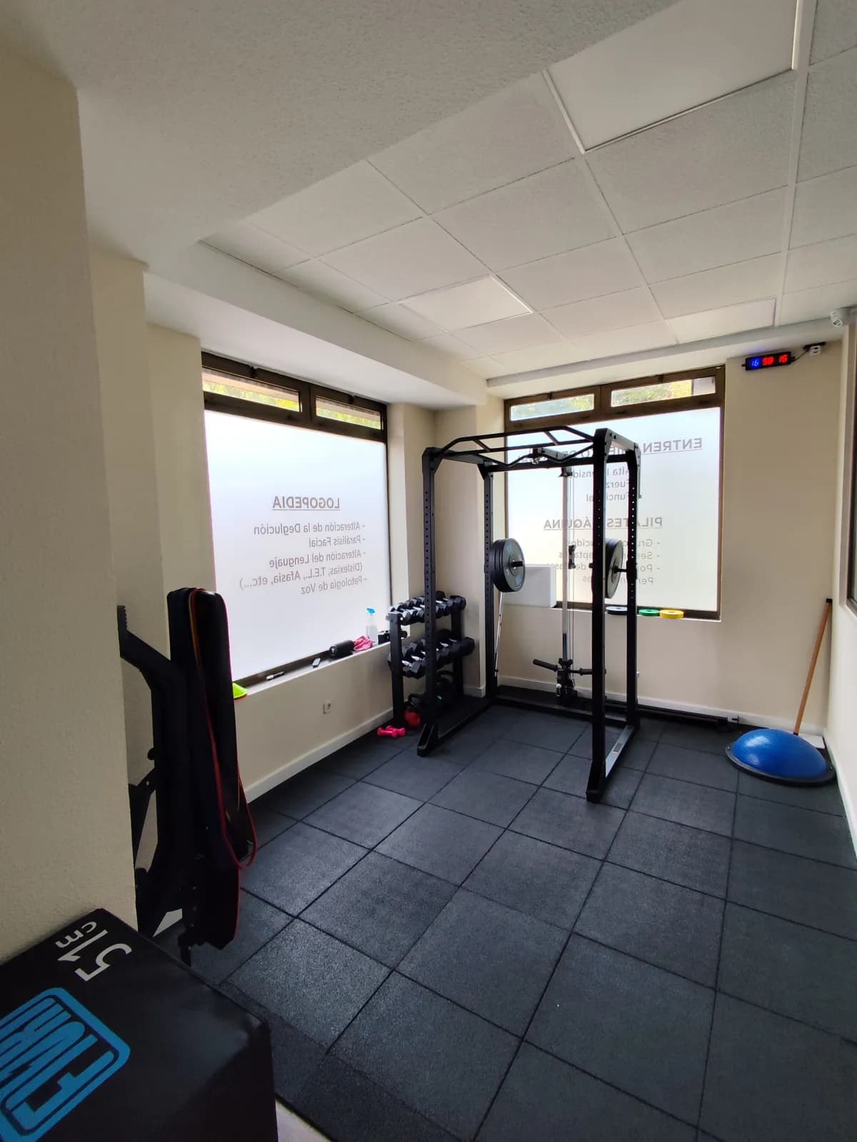 Zona de entrenamiento personal con rack y equipamiento en Clínica Prisma