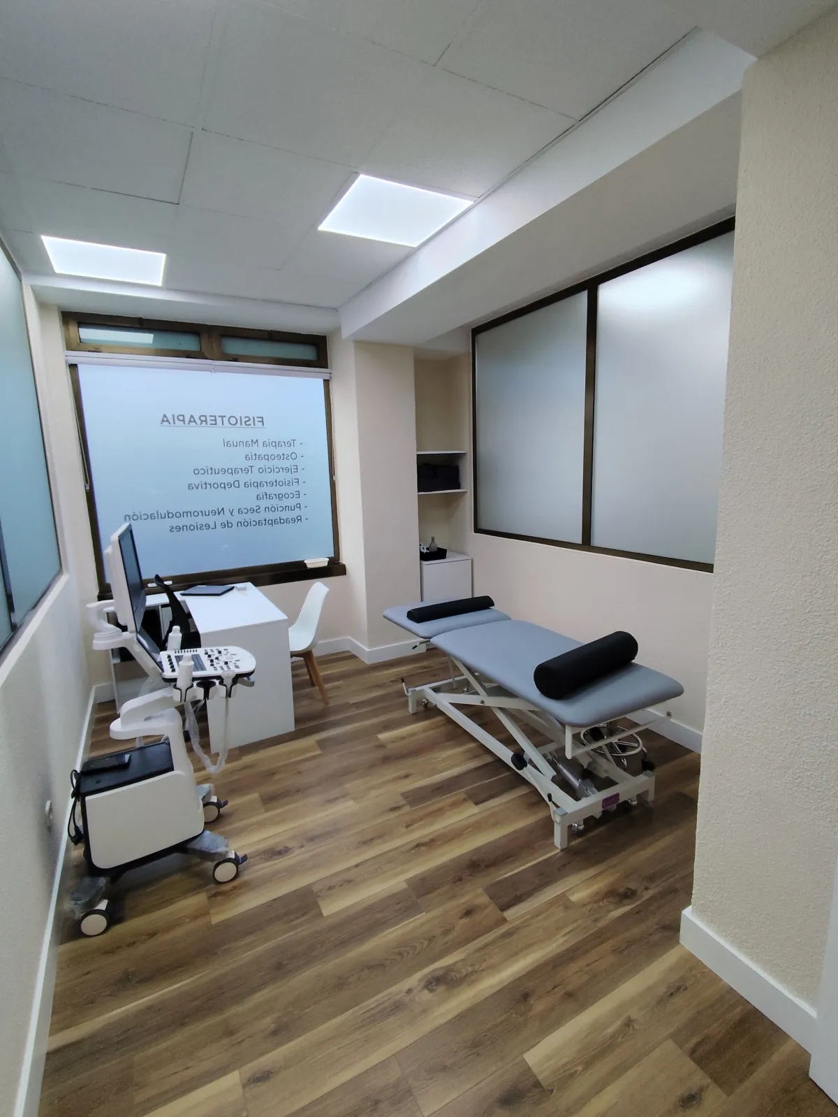 Sala de fisioterapia con camilla y ecógrafo en Clínica Prisma